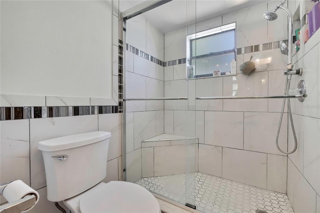 14154 Trollman Street Spring Hill, FL 34609 - Photo 13 of 25 a bathroom with a toilet and a shower