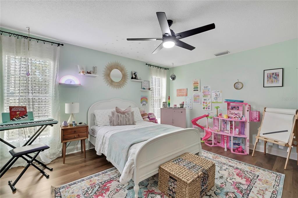 14154 Trollman Street Spring Hill, FL 34609 - Photo 14 of 25 a bedroom with a bed and furniture