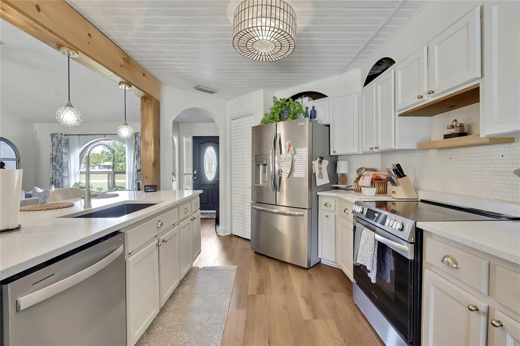 14154 Trollman Street Spring Hill, FL 34609 - Photo 7 of 25 a kitchen with refrigerator cabinets and a wooden floor