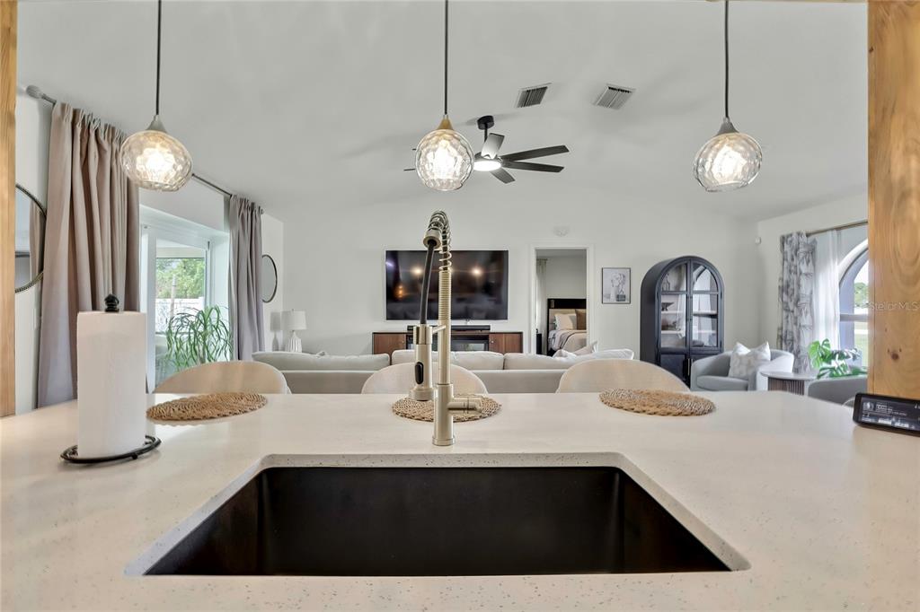 14154 Trollman Street Spring Hill, FL 34609 - Photo 8 of 25 a kitchen with a sink a chandelier and living room view