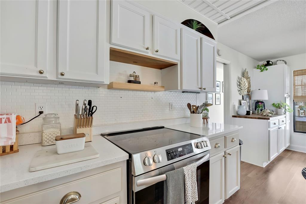 14154 Trollman Street Spring Hill, FL 34609 - Photo 9 of 25 a kitchen with a stove and white cabinets