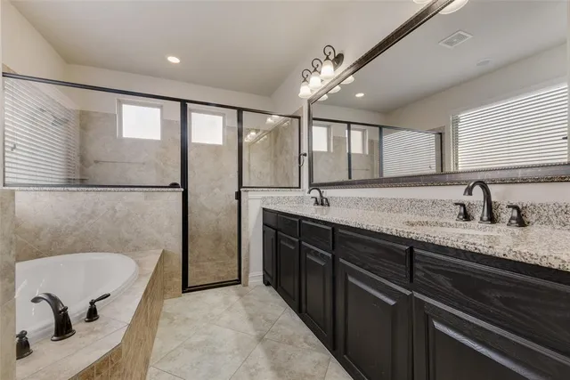 a spacious bathroom with a granite countertop sink mirror and bathtub