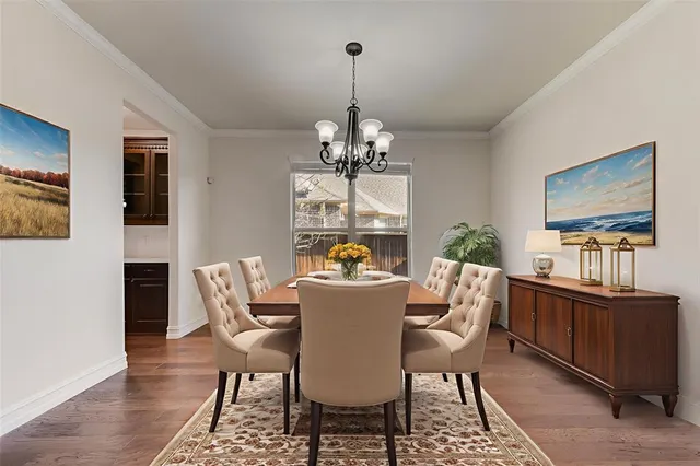 a dining room with furniture a chandelier and wooden floor