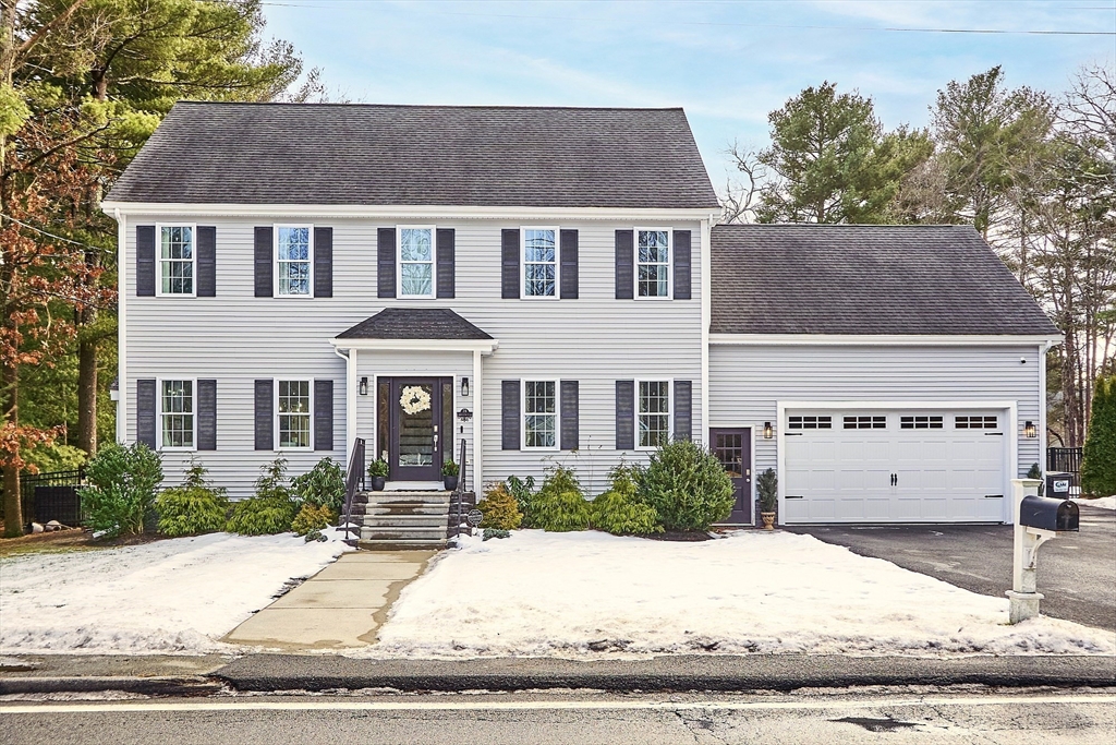 a front view of a house with a yard and a garage
