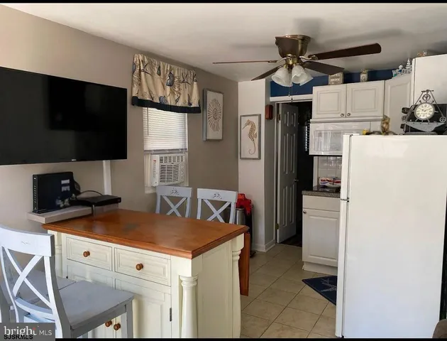 a kitchen with a refrigerator and a stove top oven