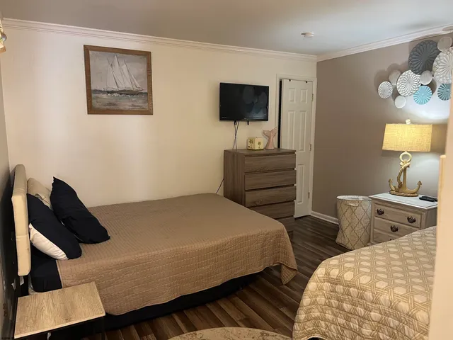a bedroom with a bed and a flat tv screen on the dresser