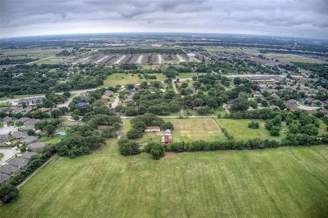 an aerial view of residential houses with outdoor space and trees