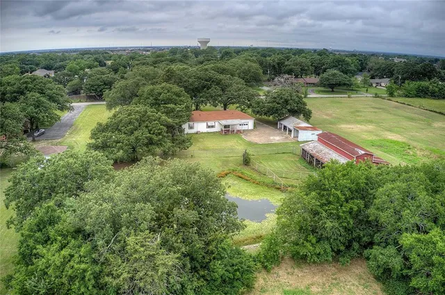 an aerial view of a house with outdoor space swimming pool patio and lake view