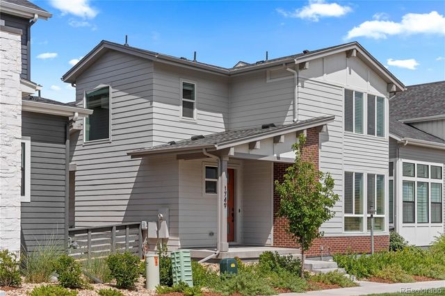 a front view of a house with a yard and potted plants