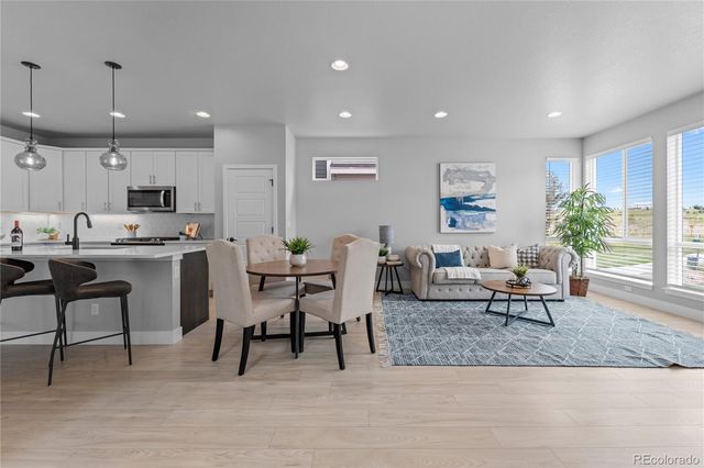 a living room with furniture and a dining table with wooden floor