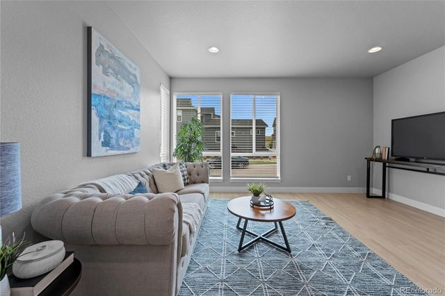 a living room with furniture a rug and a window