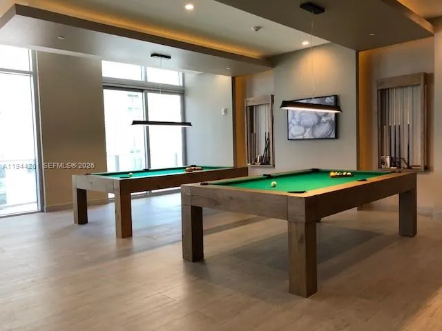 a room with pool table and windows