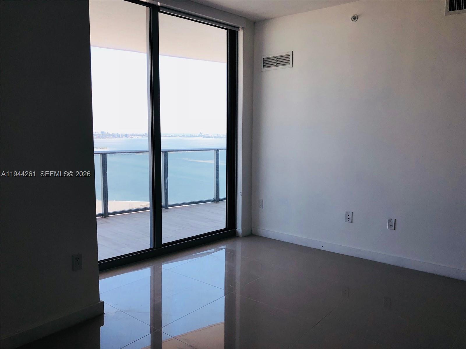 488 Northeast 18th Street, Unit 3703 Miami, FL 33132 - Photo 20 of 27 a view of an empty room with wooden floor and windows