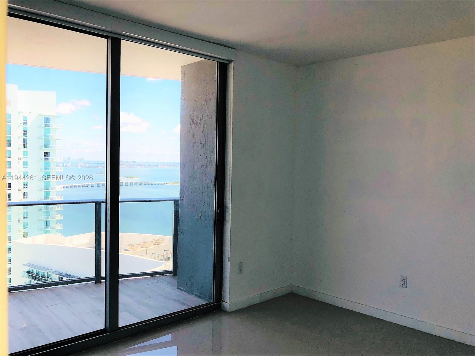 488 Northeast 18th Street, Unit 3703 Miami, FL 33132 - Photo 21 of 27 an empty room with glass door