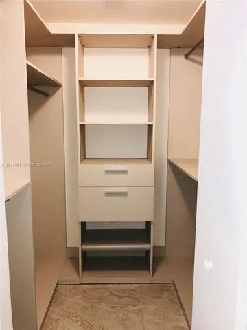 a view of walk in closet with empty racks