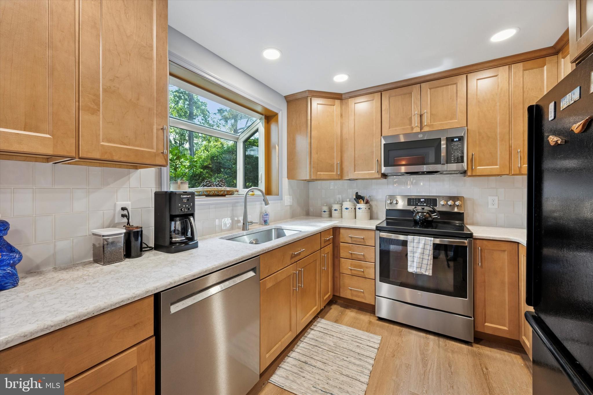 1208 Bruce Road Wilmington, DE 19803 - Photo 9 of 38 a kitchen with stainless steel appliances granite countertop a sink a stove a microwave and cabinets