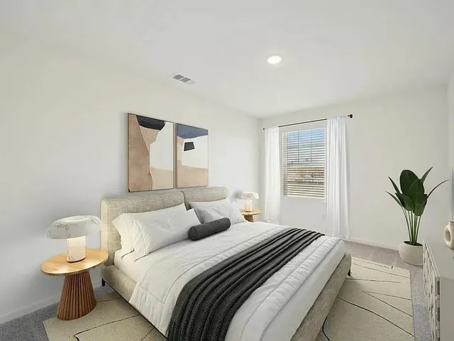 a bedroom with a bed and a potted plant