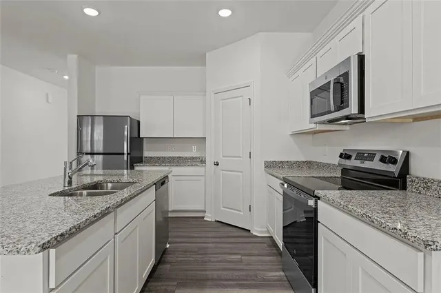 a kitchen with stainless steel appliances granite countertop a sink stove and refrigerator
