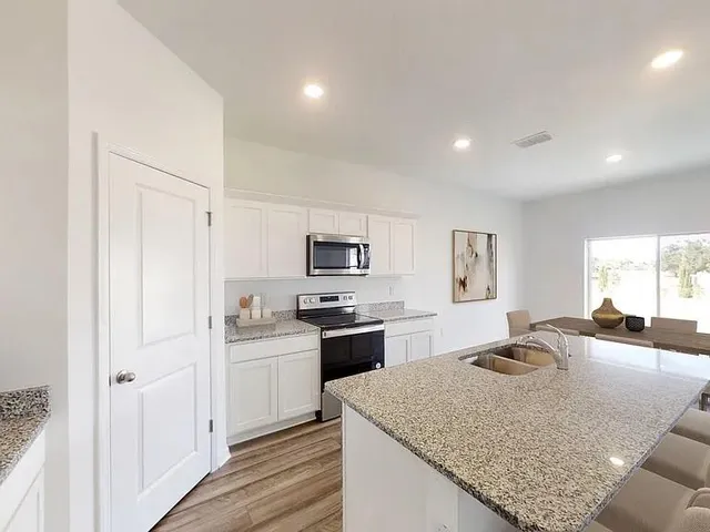 a kitchen with stainless steel appliances granite countertop a sink dishwasher stove and refrigerator