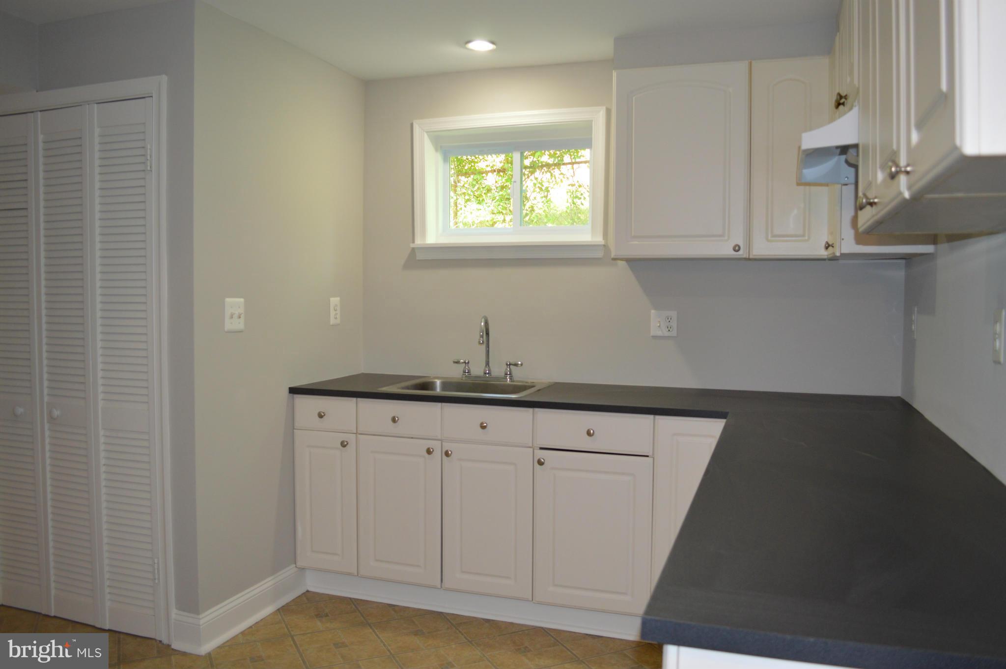 4238 Isbell Street Silver Spring, MD 20906 - Photo 21 of 22 a kitchen with granite countertop white cabinets and sink