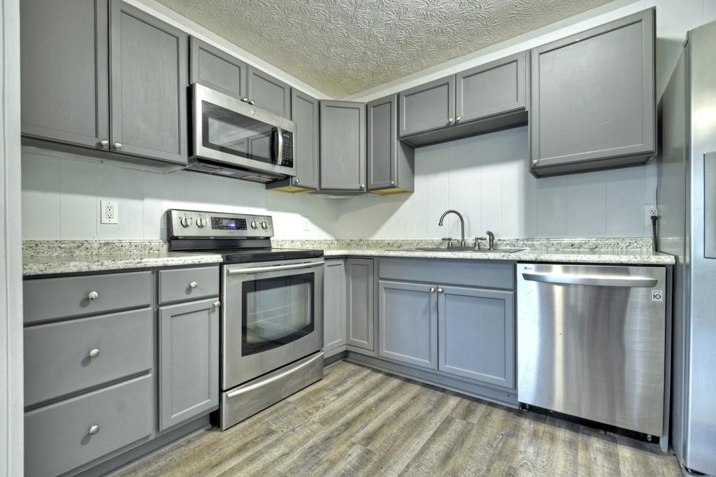 870-868 Sugar Creek Road Blue Ridge, GA 30513 - Photo 11 of 84 a kitchen with stainless steel appliances granite countertop a sink a stove and microwave with wooden floor