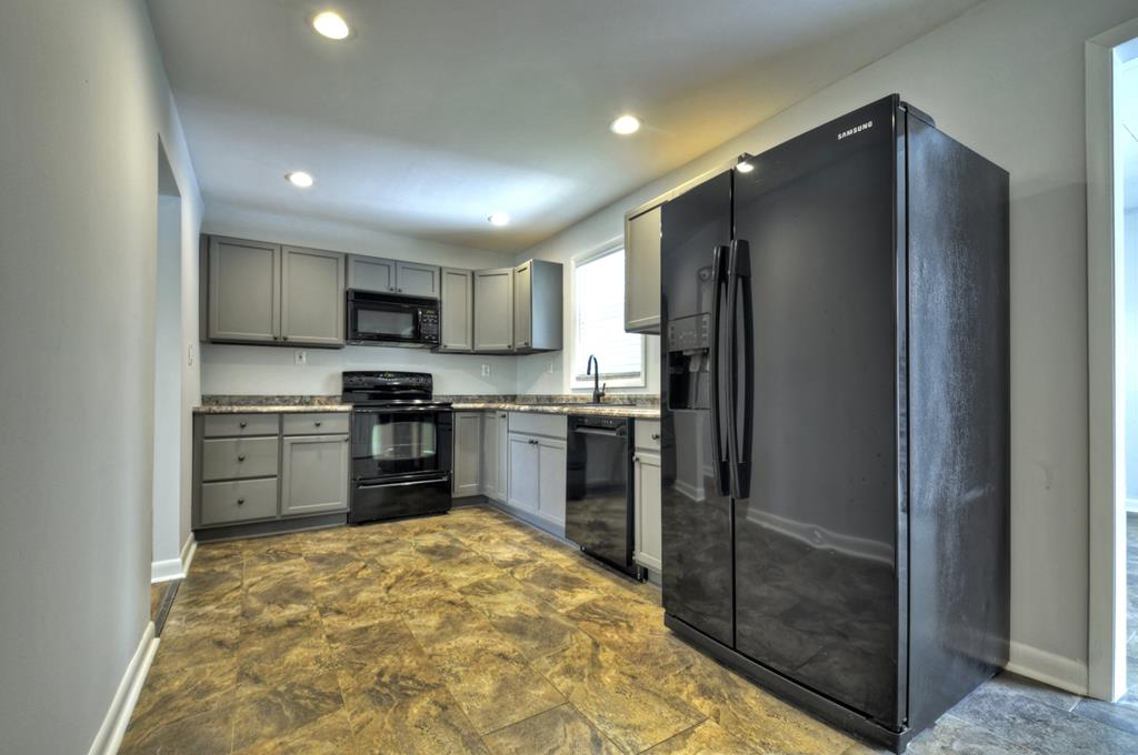 870-868 Sugar Creek Road Blue Ridge, GA 30513 - Photo 43 of 84 a kitchen with granite countertop a refrigerator and a stove top oven