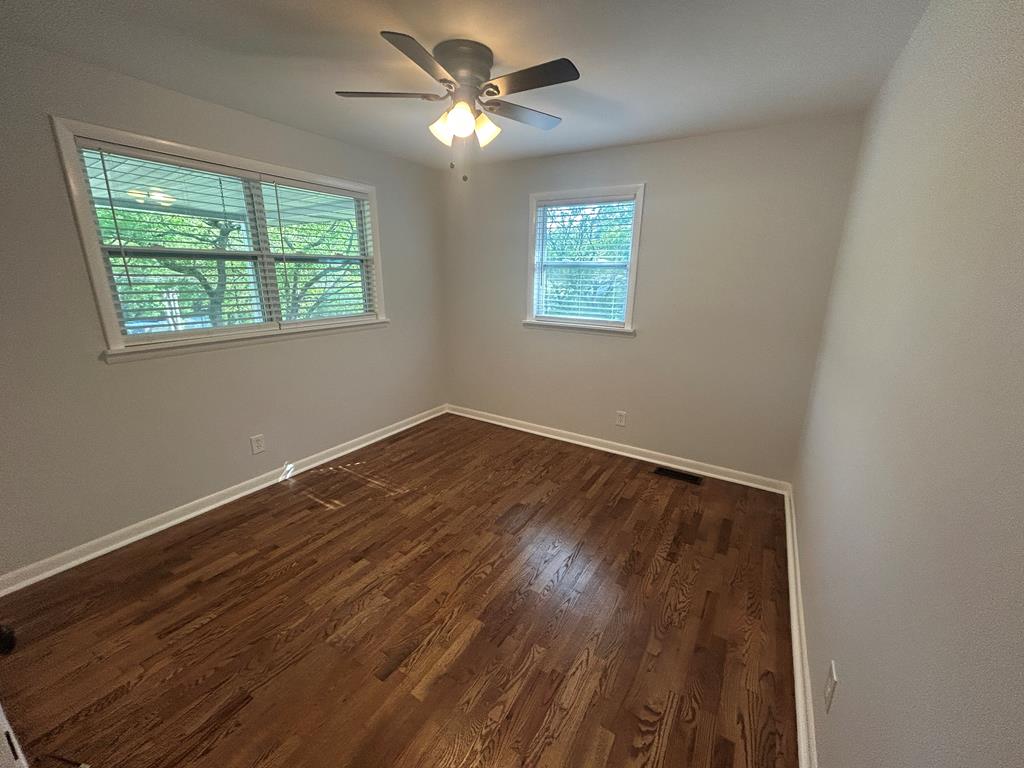 870-868 Sugar Creek Road Blue Ridge, GA 30513 - Photo 69 of 84 an empty room with wooden floor chandelier fan and windows