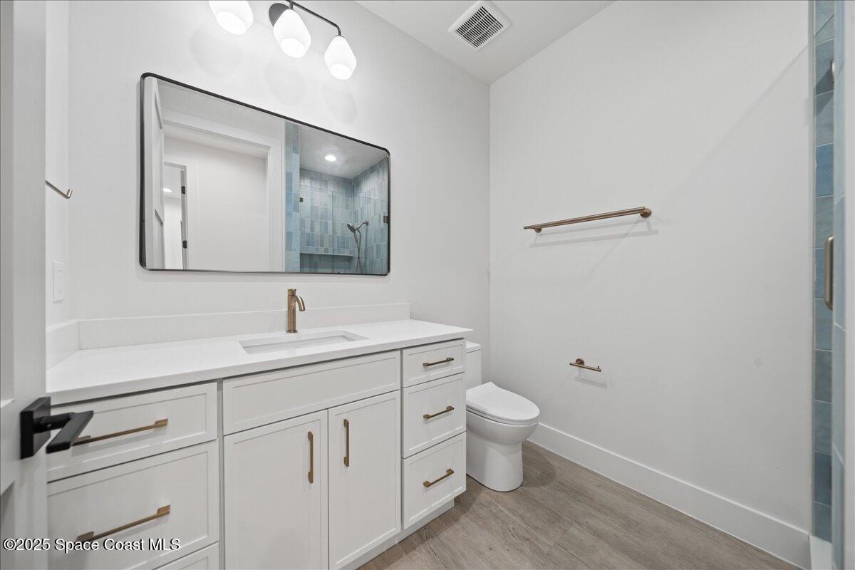 1004 Wave Crest Avenue Indialantic, FL 32903 - Photo 16 of 51 a bathroom with a toilet sink and mirror