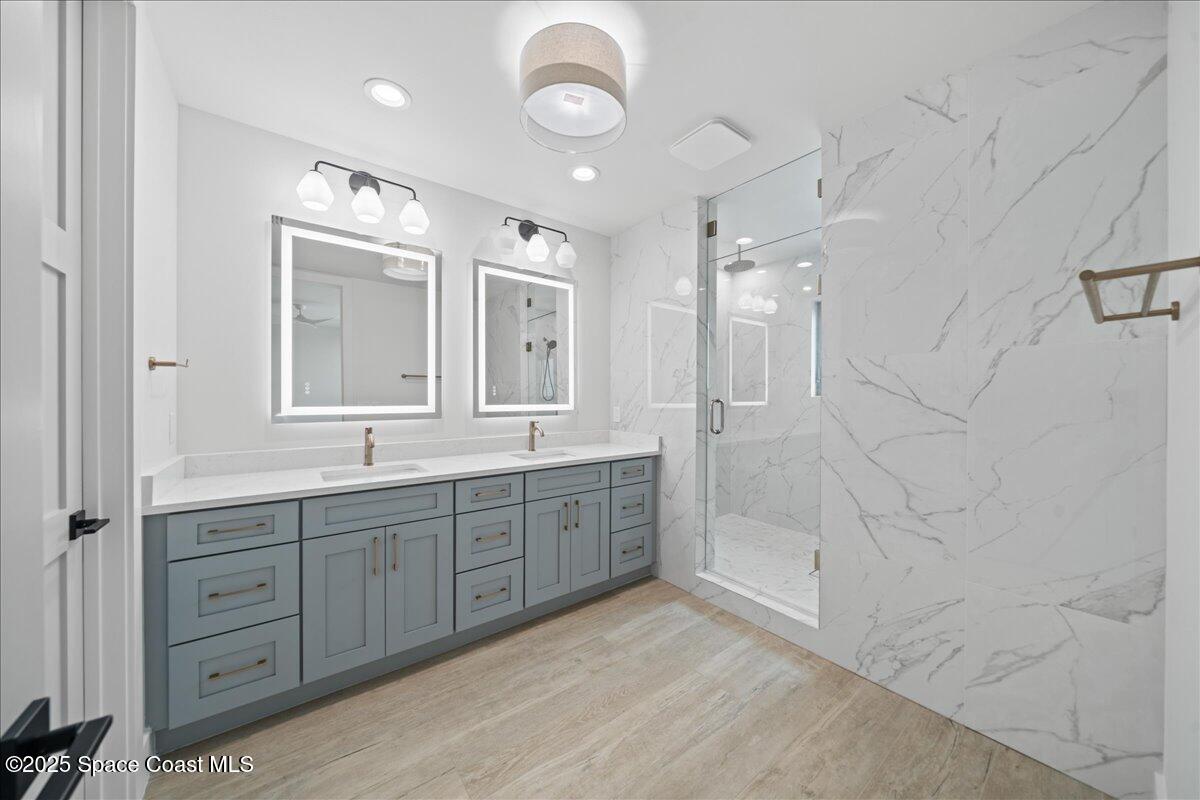 1004 Wave Crest Avenue Indialantic, FL 32903 - Photo 28 of 51 a spacious bathroom with a granite countertop sink a toilet a mirror and shower