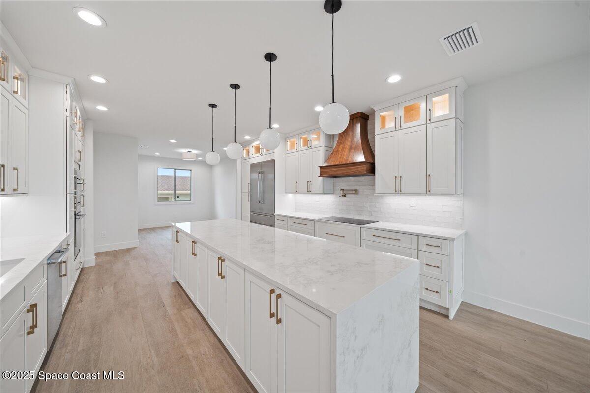1004 Wave Crest Avenue Indialantic, FL 32903 - Photo 8 of 51 a large kitchen with kitchen island a large island a sink stainless steel appliances and wooden floor