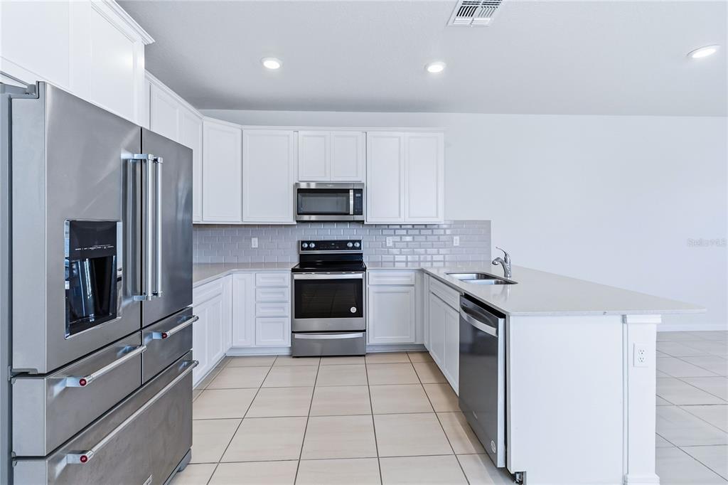 10379 Folly Beach Road Orlando, FL 32827 - Photo 23 of 56 a kitchen with a refrigerator and a stove