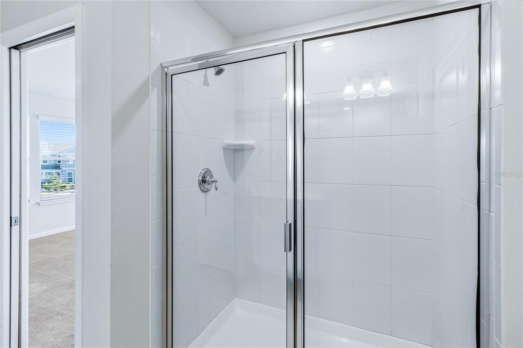 10379 Folly Beach Road Orlando, FL 32827 - Photo 33 of 56 a bathroom with a glass shower door
