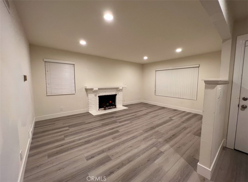 6939 Tahiti Drive Cypress, CA 90630 - Photo 4 of 15 an empty room with wooden floor and fireplace