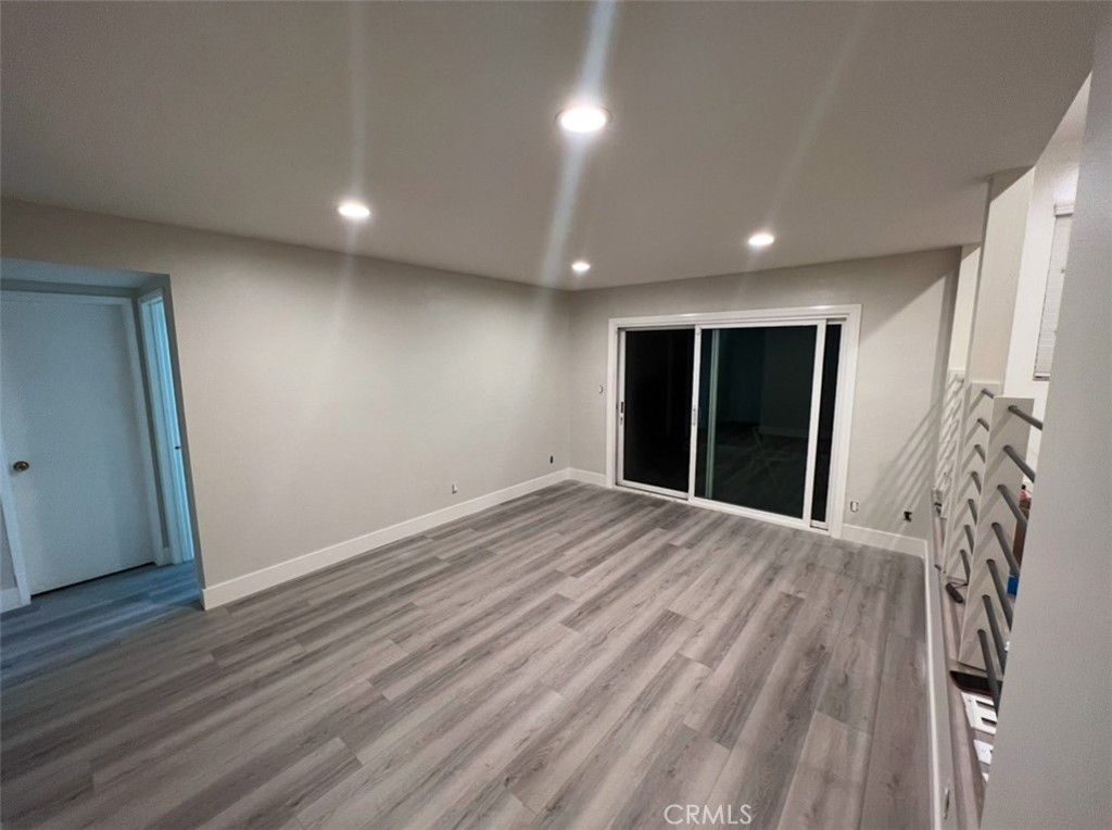 6939 Tahiti Drive Cypress, CA 90630 - Photo 5 of 15 a view of an empty room with wooden floor and a window
