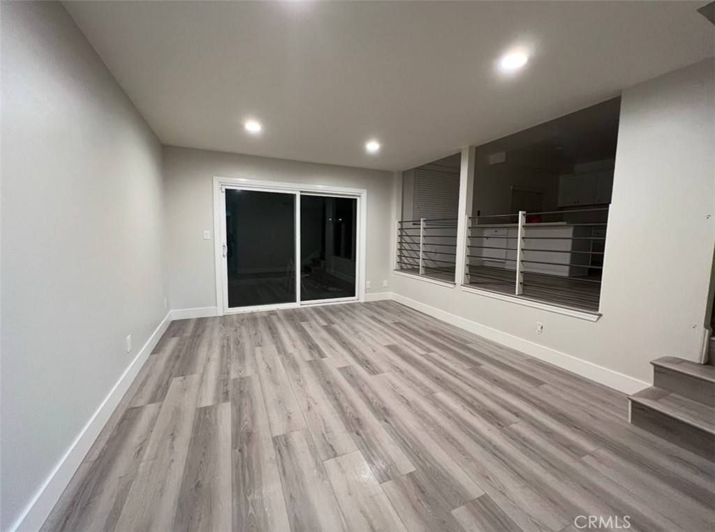 6939 Tahiti Drive Cypress, CA 90630 - Photo 8 of 15 a view of an empty room with wooden floor and windows