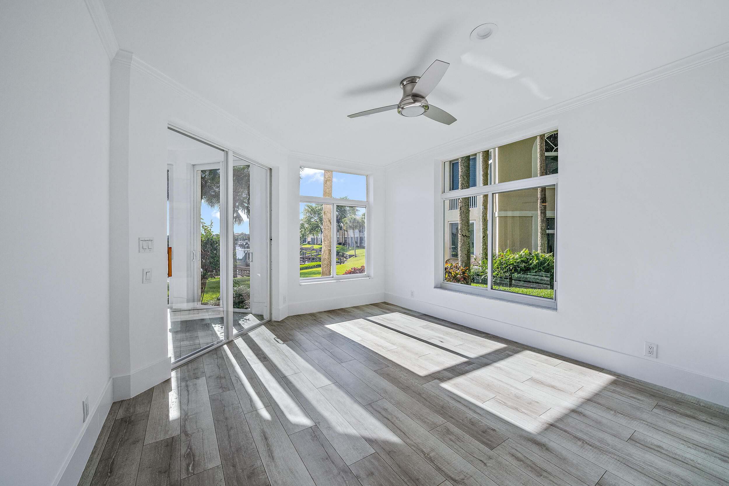 226 Eagle Drive Jupiter, FL 33477 - Photo 11 of 31 a view of an empty room with a window and wooden floor