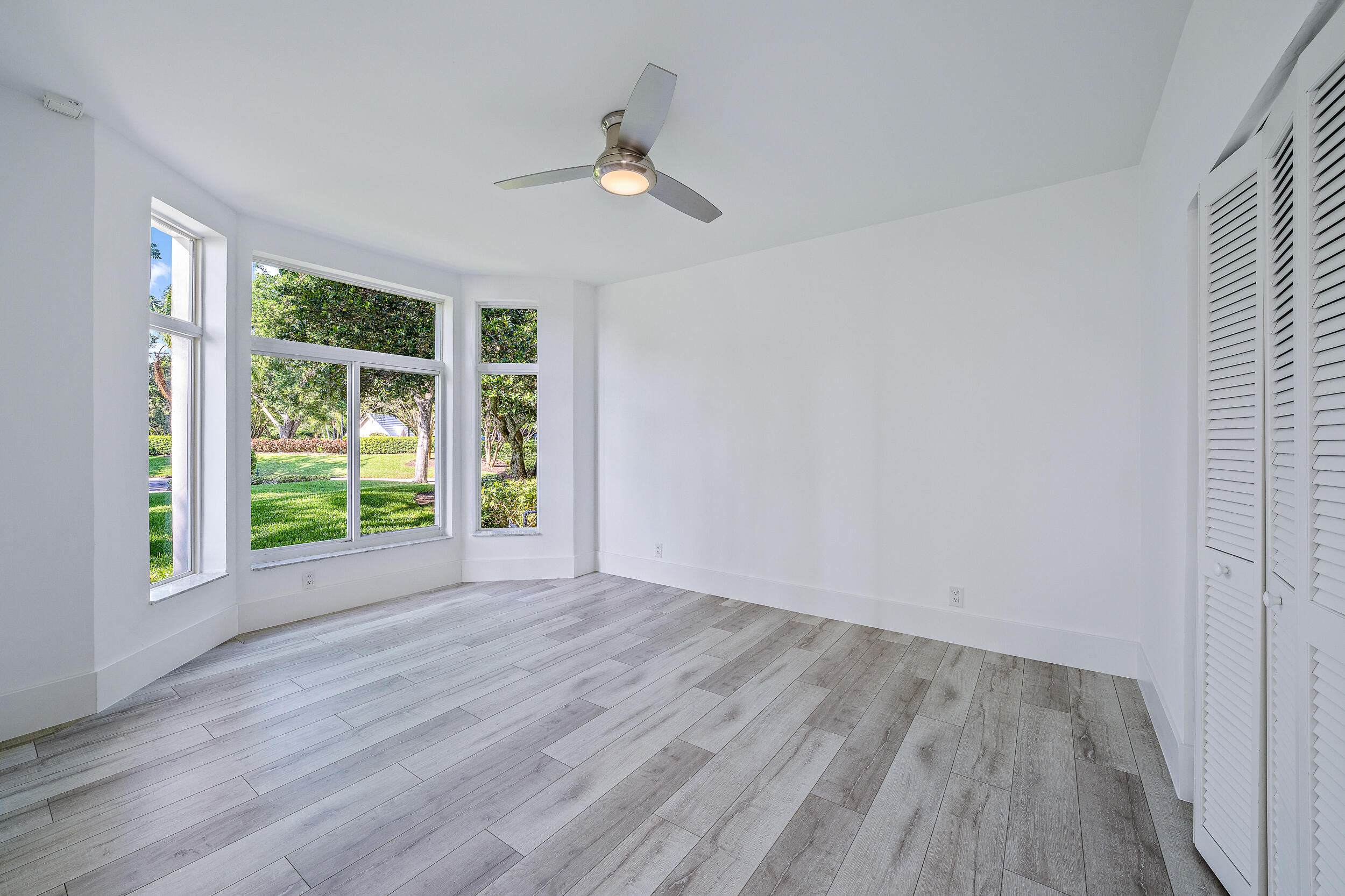 226 Eagle Drive Jupiter, FL 33477 - Photo 9 of 31 a view of an empty room with wooden floor and a window