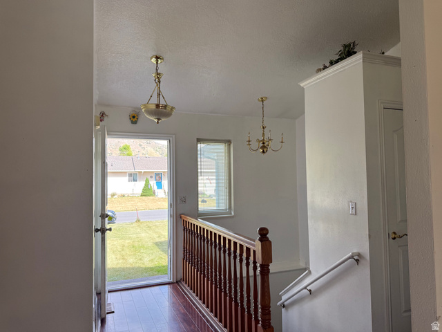 44 Wapiti Loop Hyrum, UT 84319 - Photo 5 of 18 Entryway featuring hardwood-finish flooring, a brass chandelier, and a window with blinds
