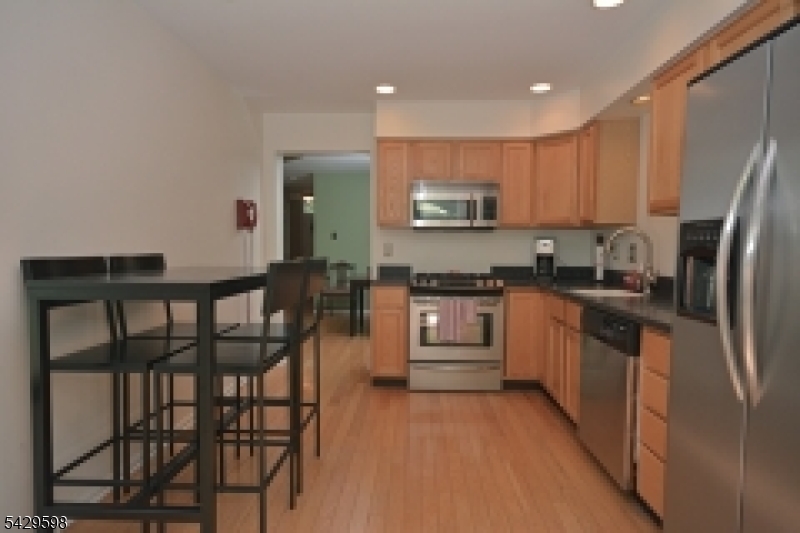 105 Well Sweep Road, Unit 105 Whitehouse Station, NJ 08889 - Photo 5 of 22 a kitchen with stainless steel appliances granite countertop a refrigerator a stove top oven and a sink
