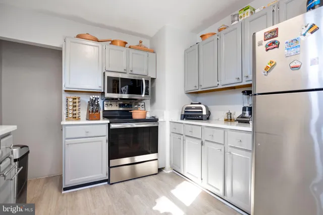 a kitchen with stainless steel appliances a refrigerator sink and microwave