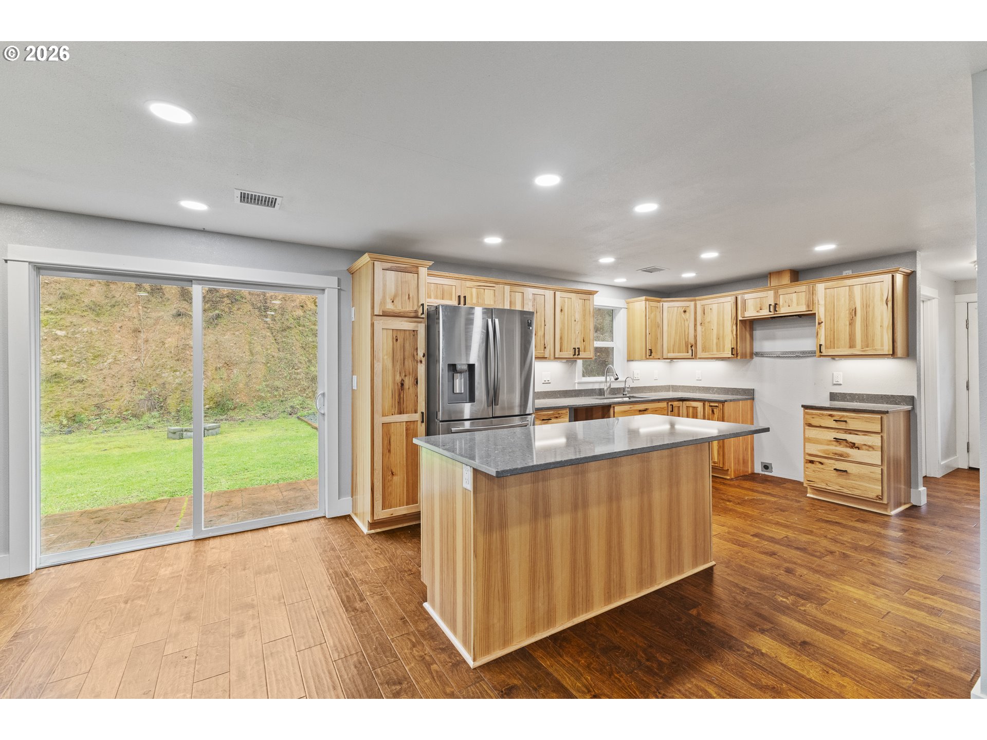 16855 Highway 42 Myrtle Point, OR 97458 - Photo 19 of 43 a open kitchen with stainless steel appliances granite countertop a refrigerator a sink dishwasher and wooden cabinets with wooden floor