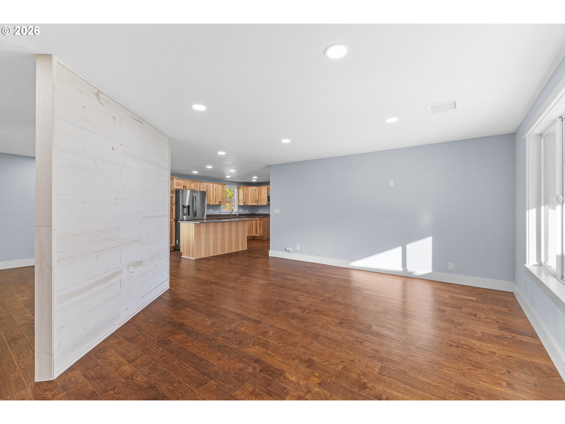 16855 Highway 42 Myrtle Point, OR 97458 - Photo 4 of 43 a view of an empty room with wooden floor and kitchen