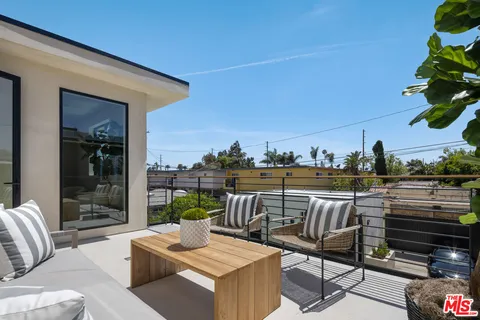 a view of a roof deck with couches and potted plants