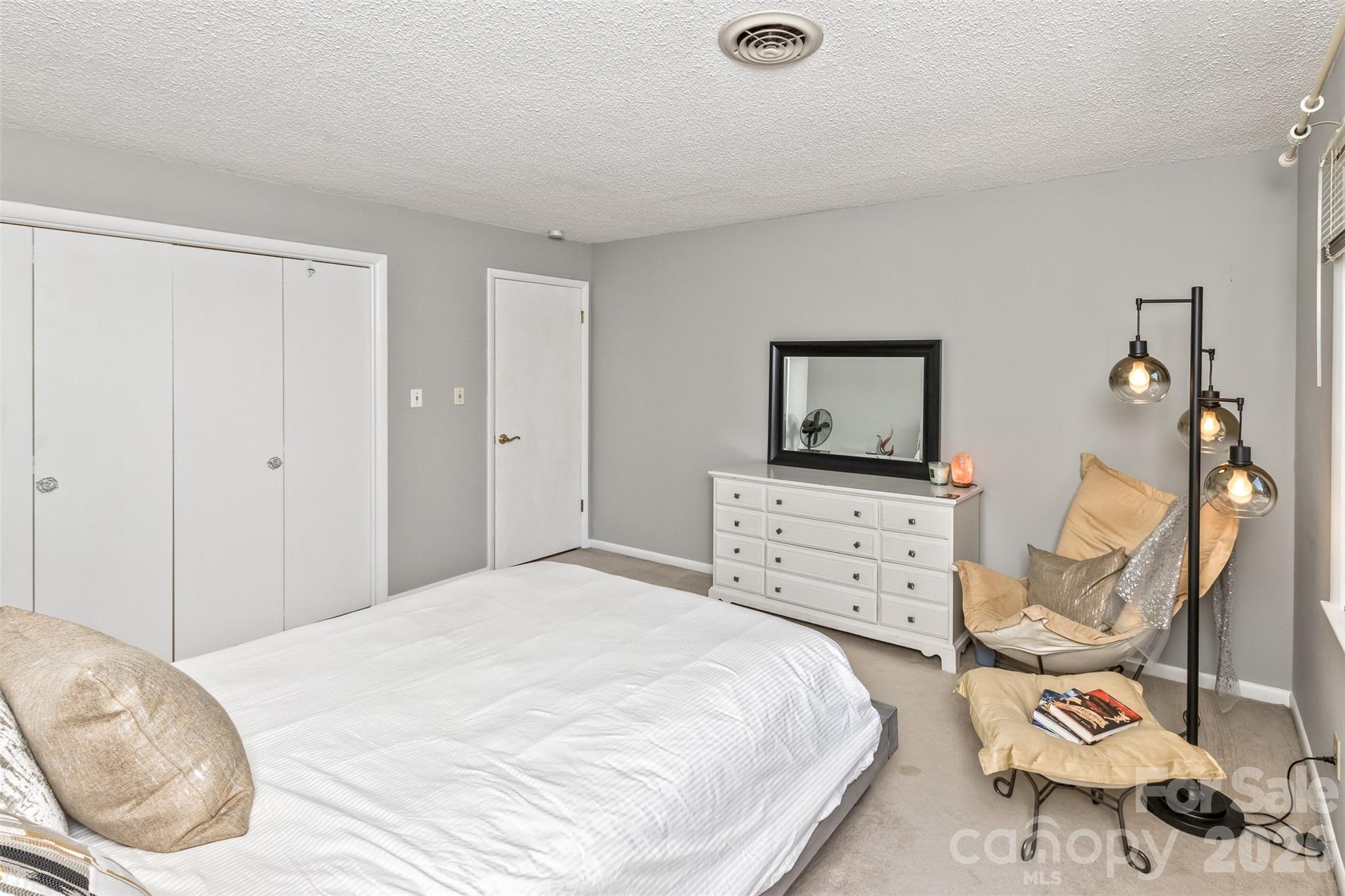 503 Crowfields Lane Asheville, NC 28803 - Photo 23 of 41 a bedroom with a bed and dresser with mirror