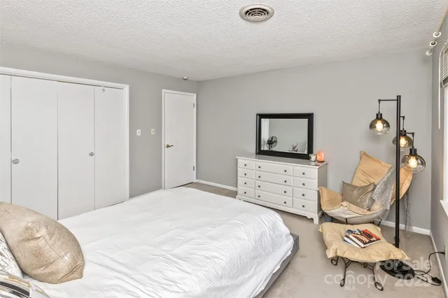 a bedroom with a bed and dresser with mirror