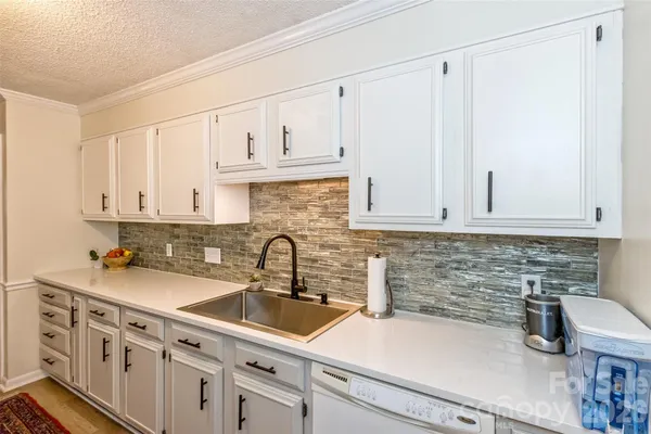 a kitchen with sink a cabinets and appliances