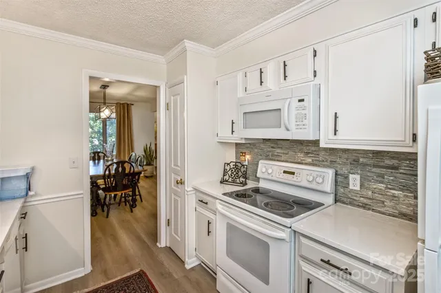 a kitchen with white cabinets and appliances