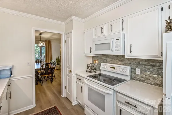 a kitchen with white cabinets and appliances