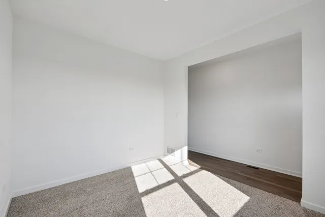 a view of an empty room and wooden floor