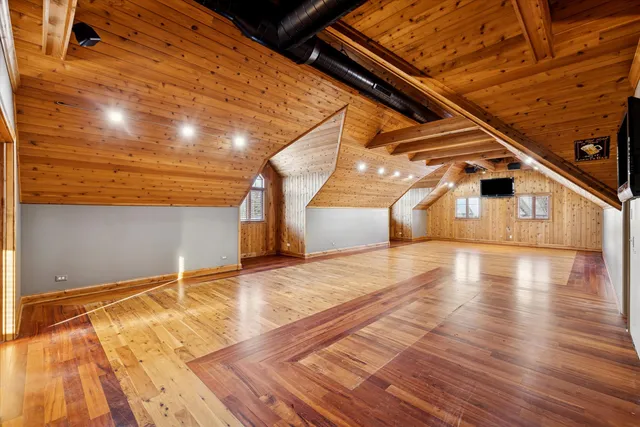 a view of empty room with wooden floor and windows
